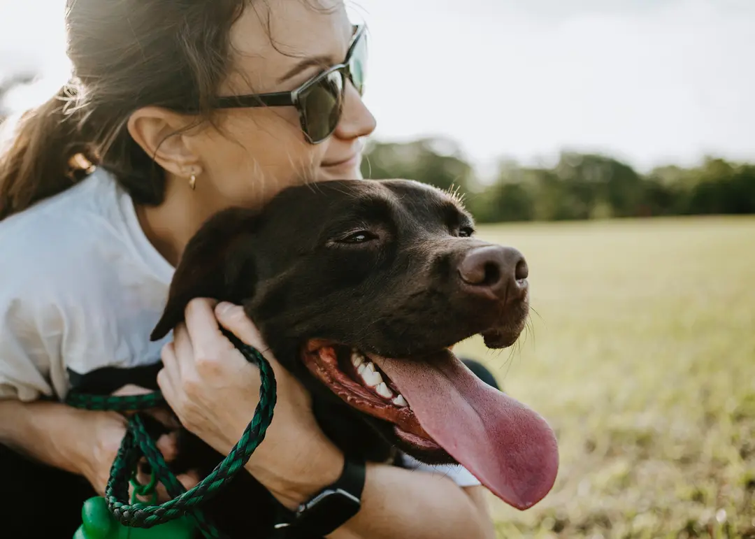 A woman smiling at her dog